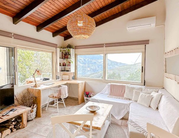 Bright living room with panoramic mountain views in Guesthouse 1