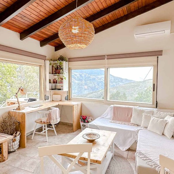 Bright living room with panoramic mountain views in Guesthouse 1